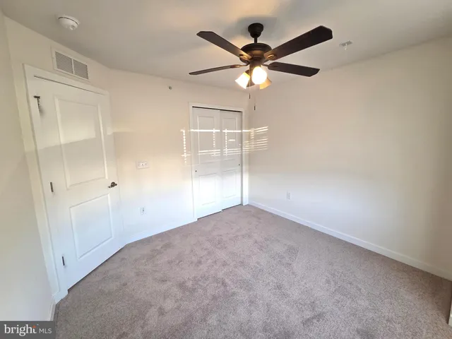 an empty room with a window and a fan