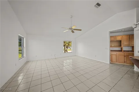 an empty room with windows and fan