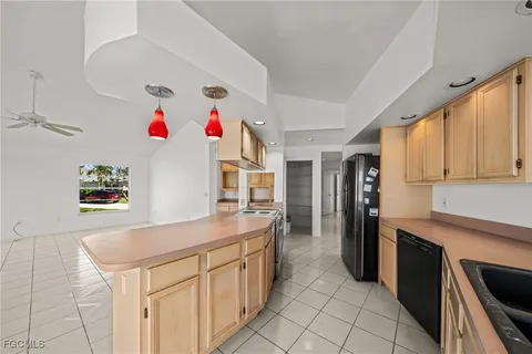a large kitchen with granite countertop a sink and cabinets
