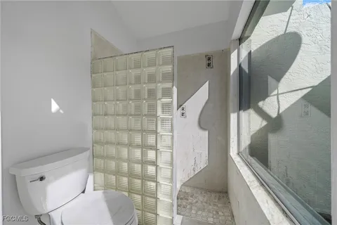 an empty room with a ceiling fan and window