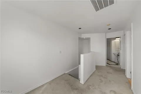 an empty room with windows and a ceiling fan