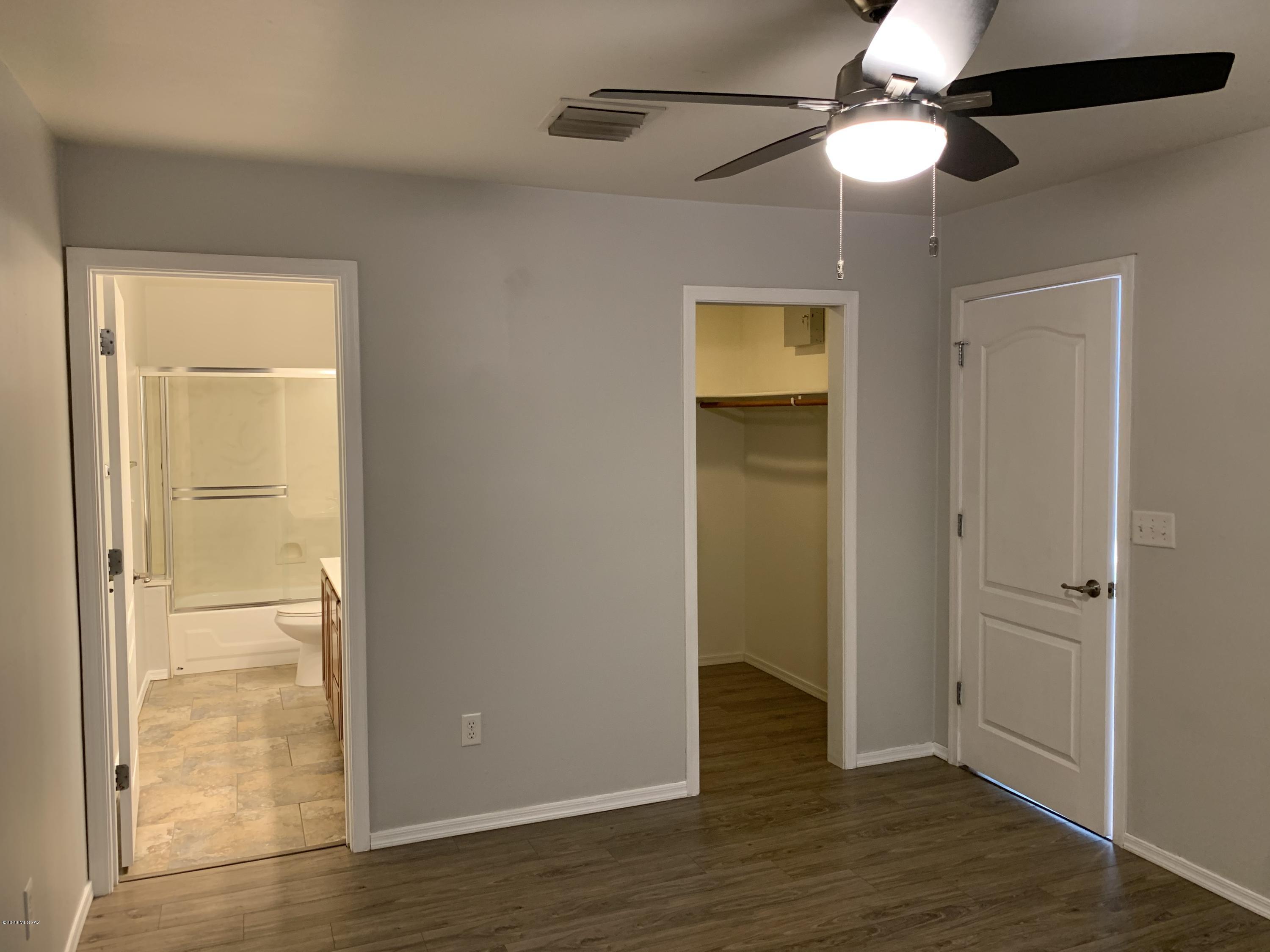 4181 North Fortune Loop Tucson, AZ 85719 - Photo 12 of 39 an empty room with wooden floor cabinet and a ceiling fan