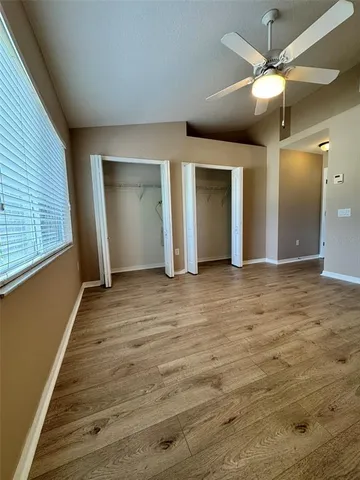 an empty room with fan and entrance