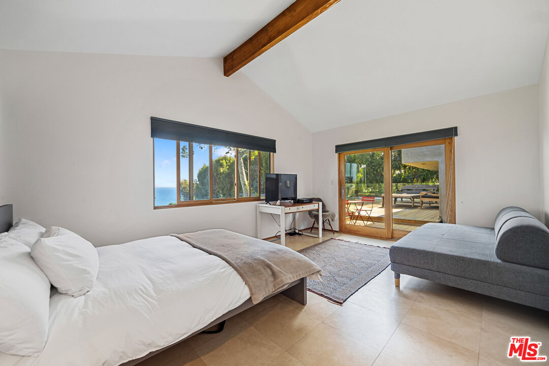 31226 Bailard Road Malibu, CA 90265 - Photo 23 of 40 a bedroom with a bed and a couch next to a window