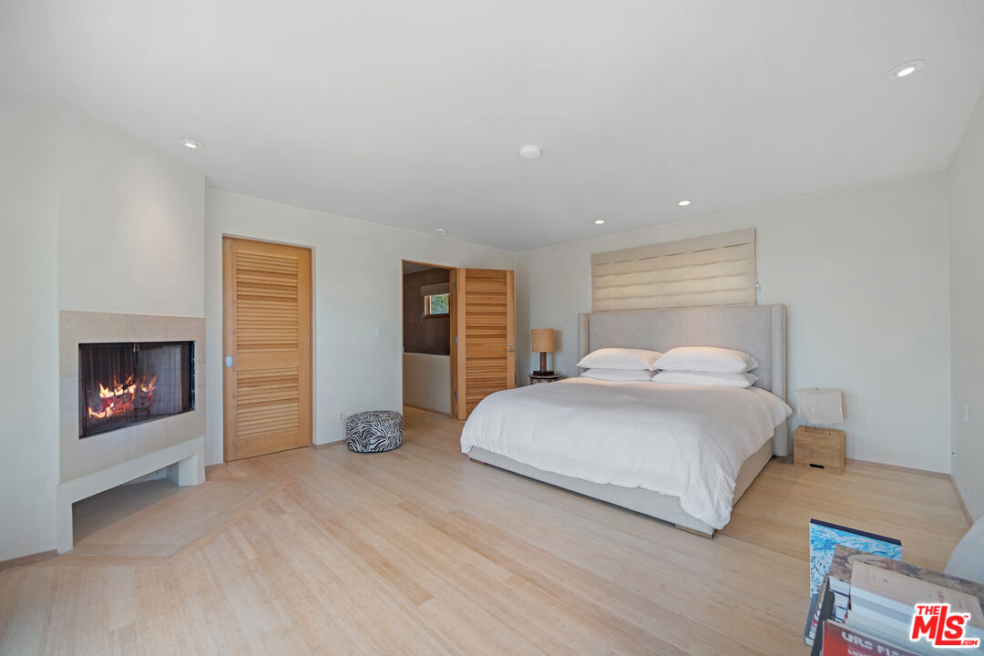 31226 Bailard Road Malibu, CA 90265 - Photo 29 of 40 a bedroom with a bed and a fireplace