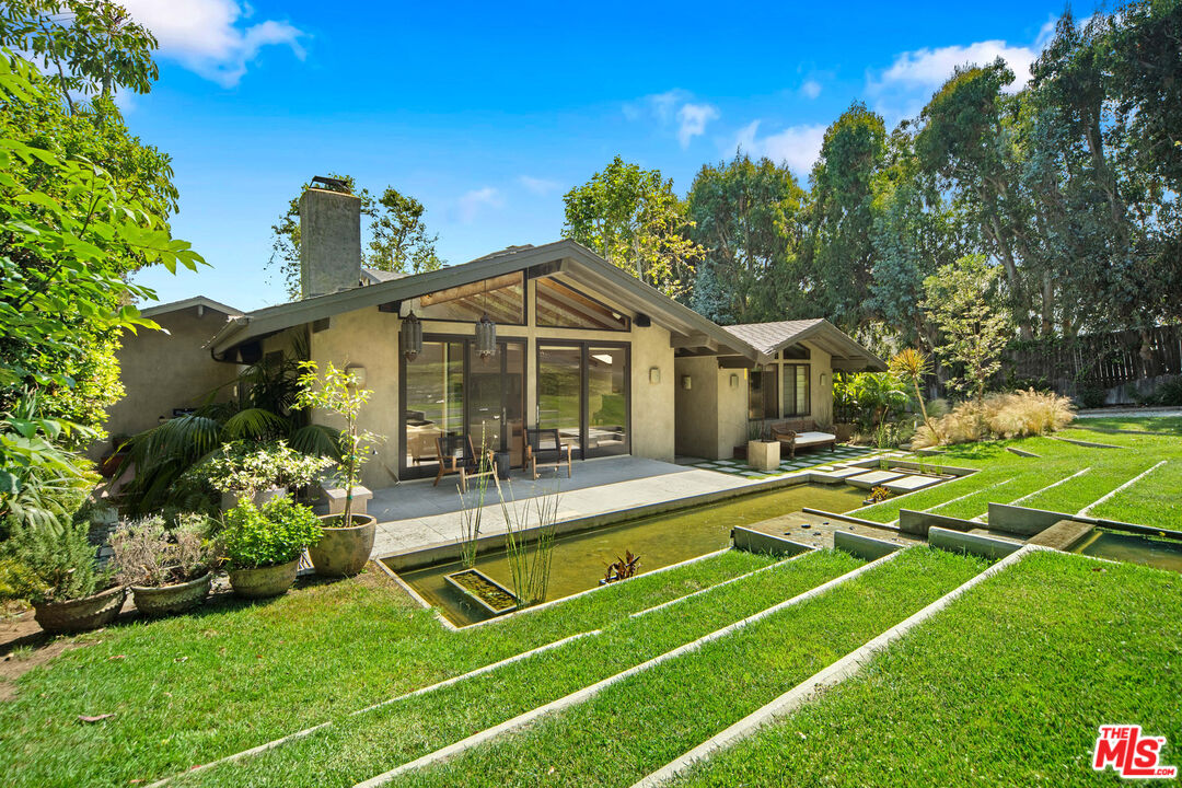 31226 Bailard Road Malibu, CA 90265 - Photo 3 of 40 a view of a house with swimming pool lawn chairs and a yard