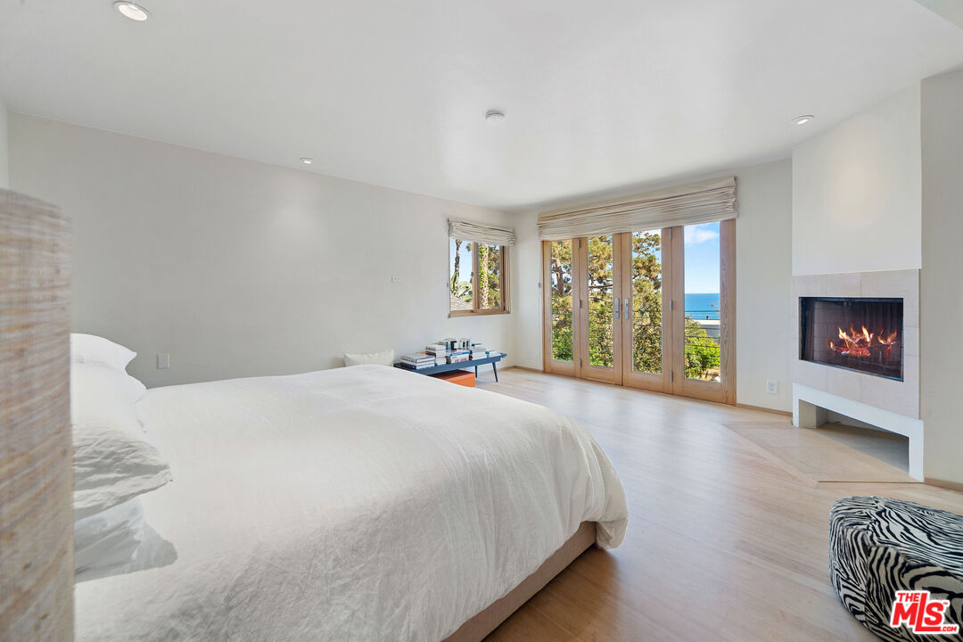 31226 Bailard Road Malibu, CA 90265 - Photo 5 of 40 a spacious bedroom with a bed and a fireplace