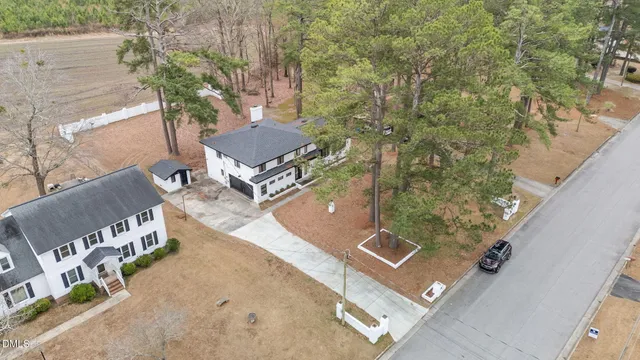 a view of a house with a yard and large trees