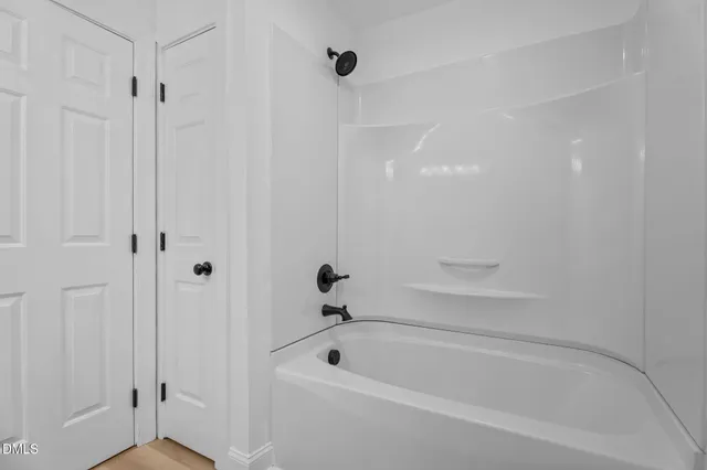 a white bath tub sitting next to a shower
