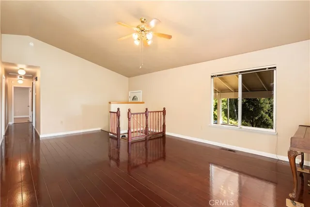 a view of a livingroom with wooden floor and a ceiling fan