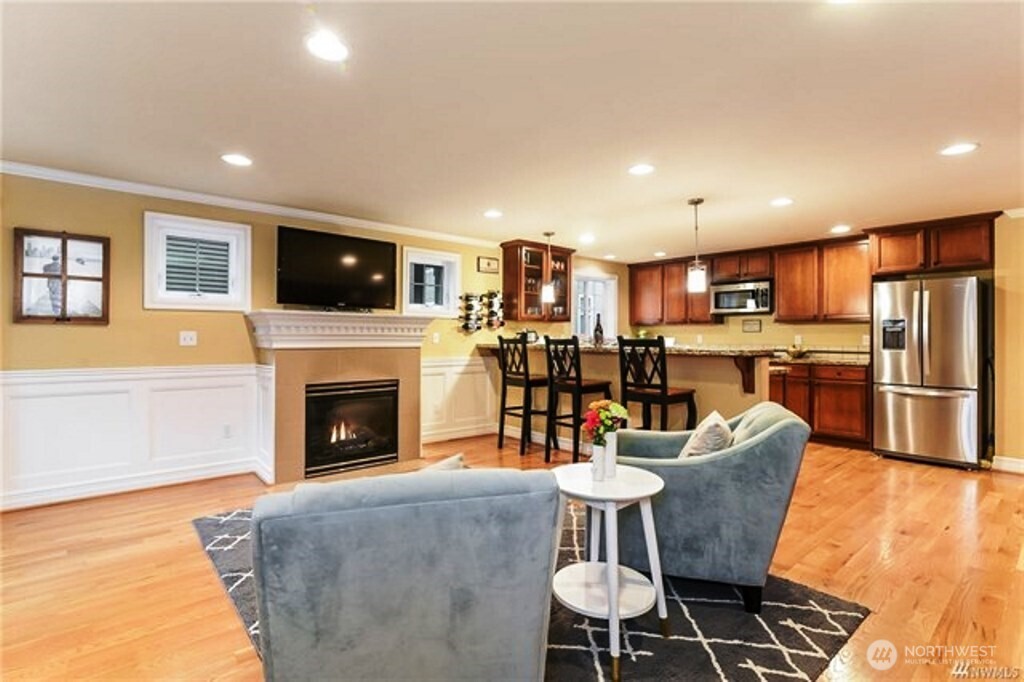 725 North 95th Street, Unit C Seattle, WA 98103 - Photo 3 of 18 a dining room with furniture a fireplace and kitchen view
