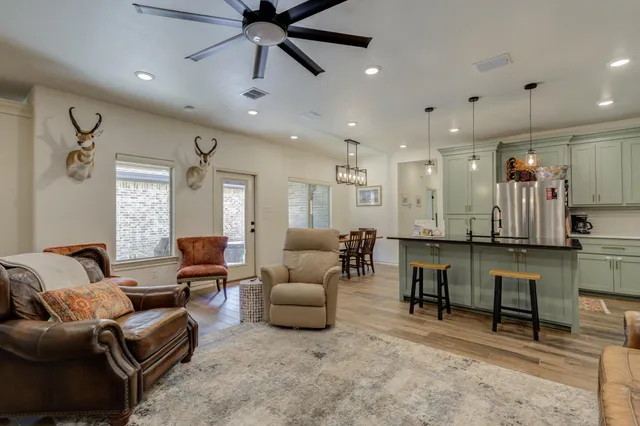 a living room with furniture and a ceiling fan