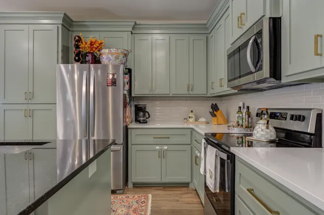 a kitchen with stainless steel appliances a refrigerator sink and cabinets
