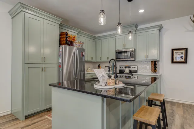 a kitchen with refrigerator and chairs