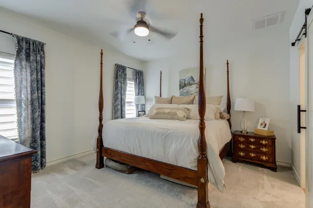 a bedroom with a bed a window and a chandelier