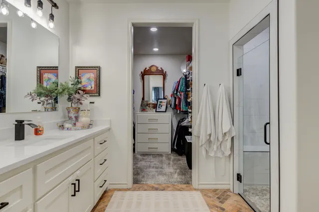 a bathroom with a double vanity sink mirror and shower