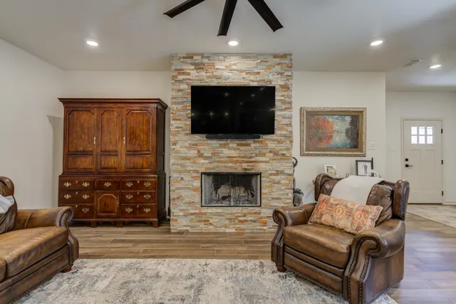 a living room with furniture a flat screen tv and a fireplace
