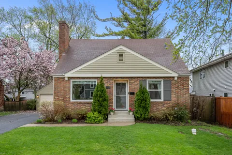 a front view of a house with a yard and green space
