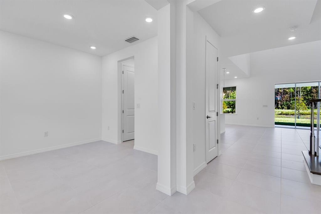 581 Moon Shell Circle New Smyrna Beach, FL 32168 - Photo 12 of 40 an empty room with windows and stairs
