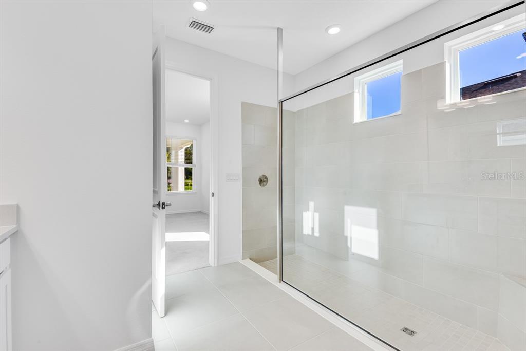 581 Moon Shell Circle New Smyrna Beach, FL 32168 - Photo 15 of 40 a view of a bathroom with a glass door shower