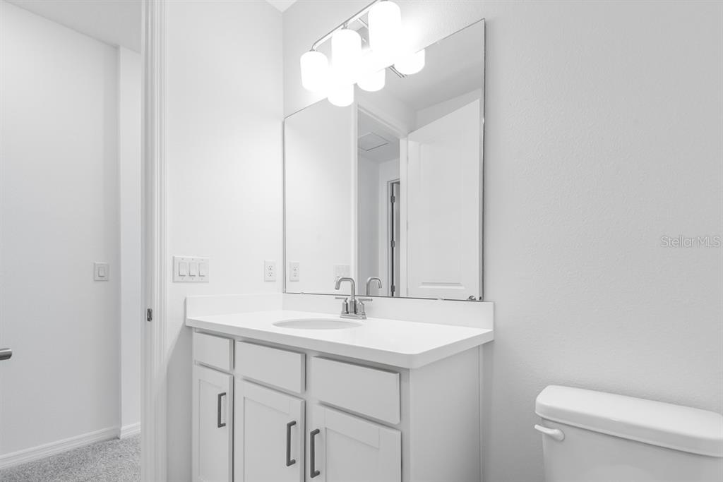581 Moon Shell Circle New Smyrna Beach, FL 32168 - Photo 25 of 40 a bathroom with a sink a toilet and a mirror