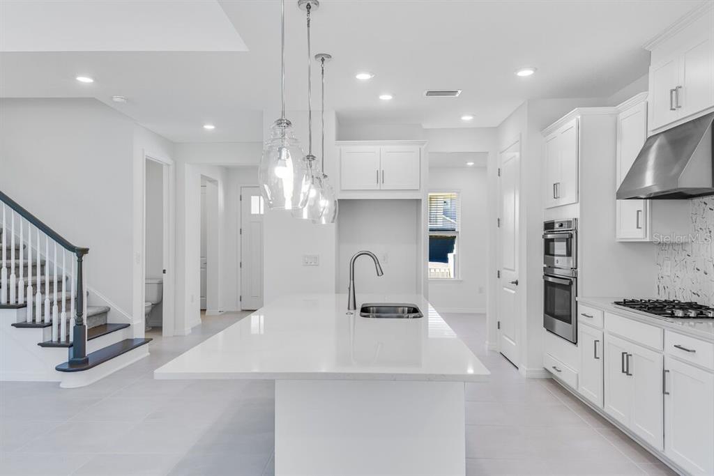 581 Moon Shell Circle New Smyrna Beach, FL 32168 - Photo 4 of 40 a kitchen with kitchen island a stove a sink and a refrigerator