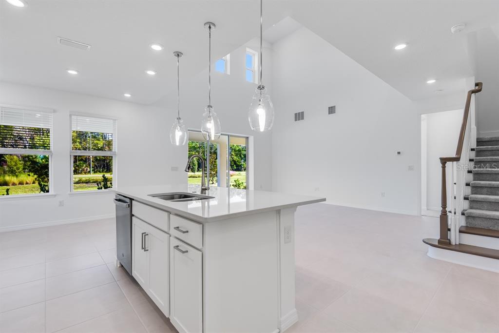 581 Moon Shell Circle New Smyrna Beach, FL 32168 - Photo 5 of 40 a kitchen with stainless steel appliances granite countertop a sink a stove and a wooden floors