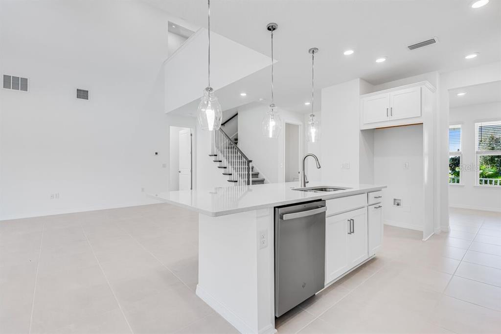 581 Moon Shell Circle New Smyrna Beach, FL 32168 - Photo 9 of 40 a kitchen with stainless steel appliances granite countertop a sink a stove and a refrigerator