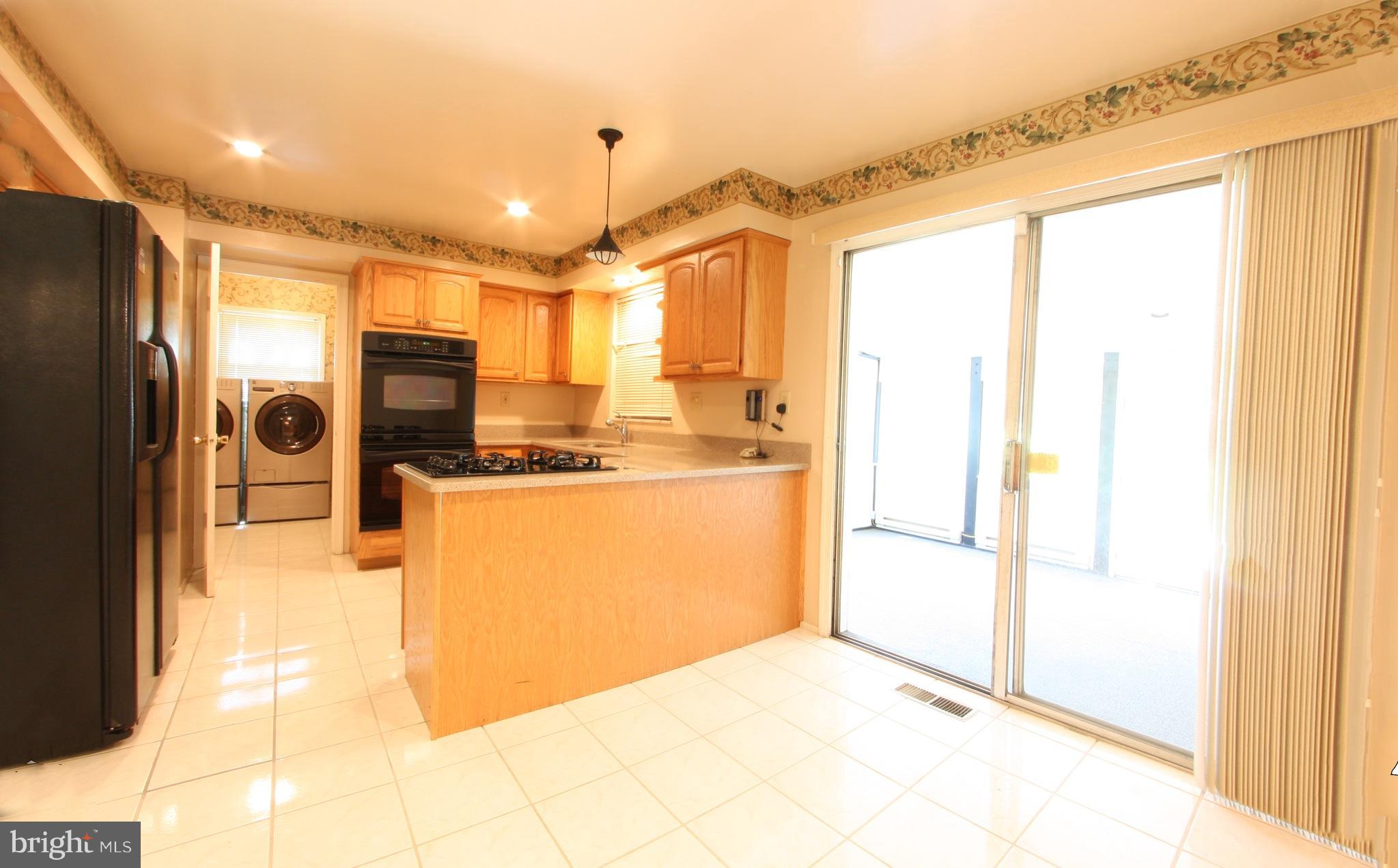 2425 Countryside Drive Silver Spring, MD 20905 - Photo 6 of 24 a view of a kitchen with a refrigerator and a sink