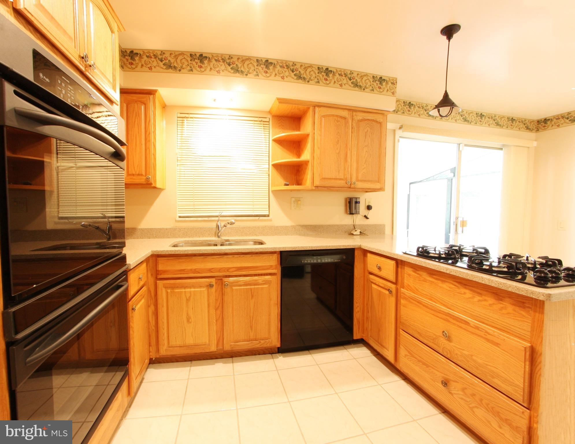 2425 Countryside Drive Silver Spring, MD 20905 - Photo 7 of 24 a kitchen with stainless steel appliances granite countertop a sink and cabinets