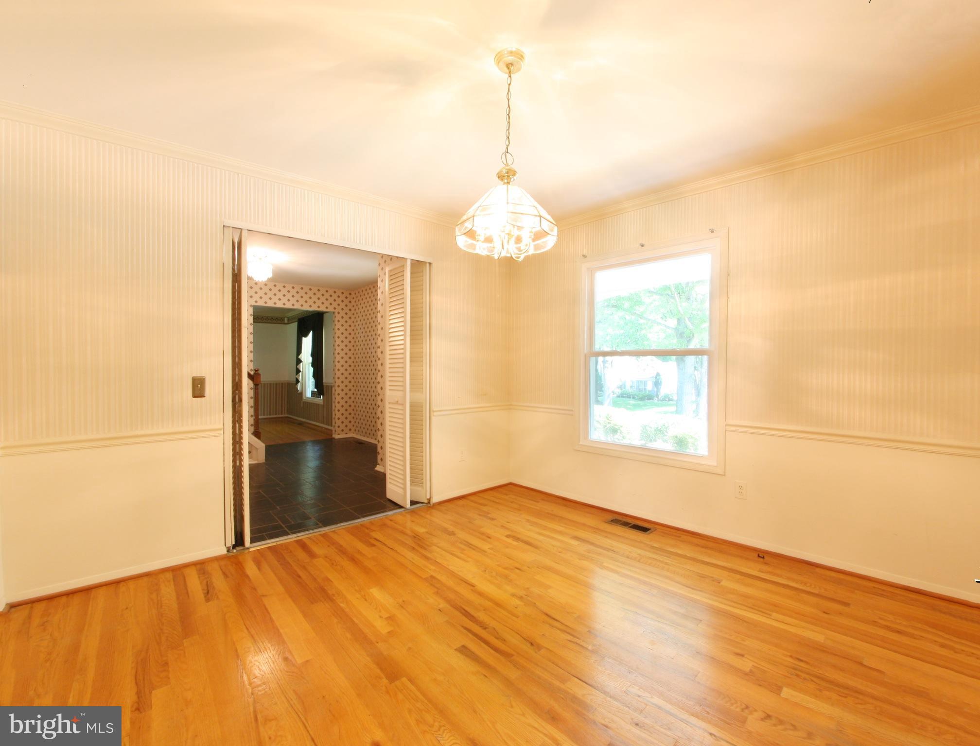 2425 Countryside Drive Silver Spring, MD 20905 - Photo 9 of 24 a bedroom with a bed and a chandelier