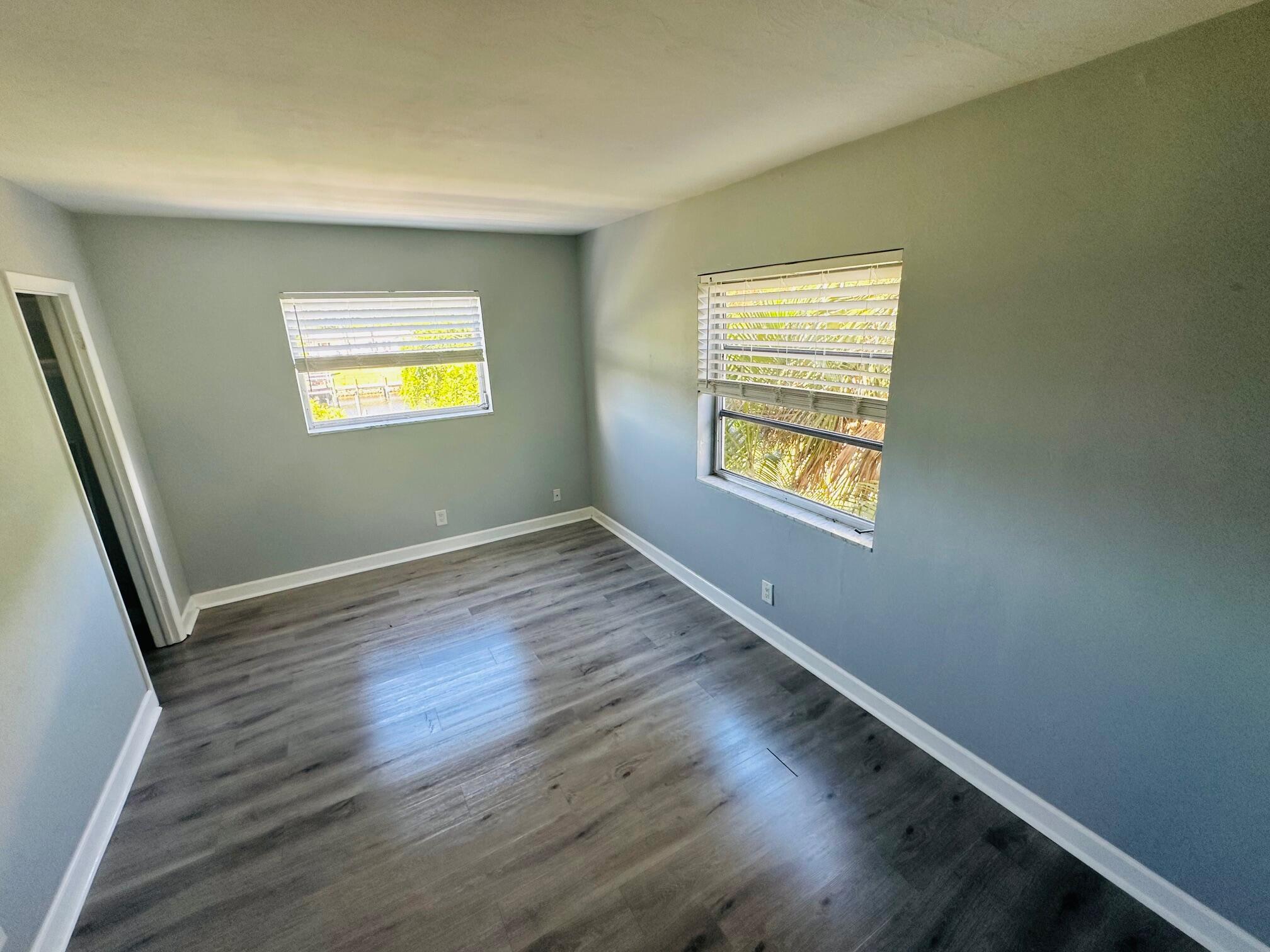 761 Hummingbird Way, Unit 205 North Palm Beach, FL 33408 - Photo 11 of 16 a view of an empty room with wooden floor and a window
