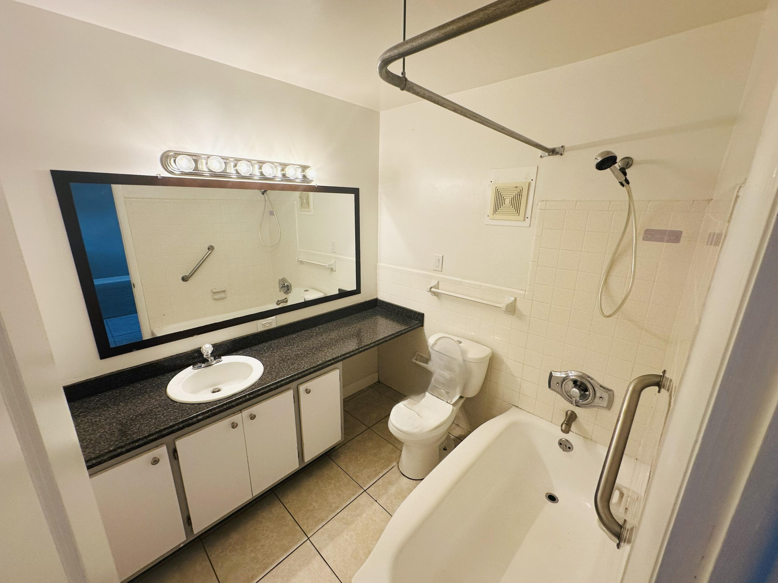 761 Hummingbird Way, Unit 205 North Palm Beach, FL 33408 - Photo 12 of 16 a bathroom with a granite countertop sink mirror vanity and toilet