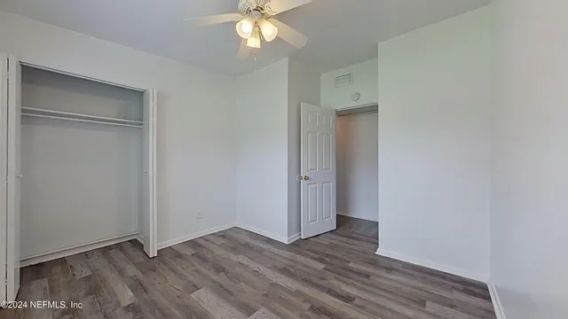 an empty room with wooden floor and closet