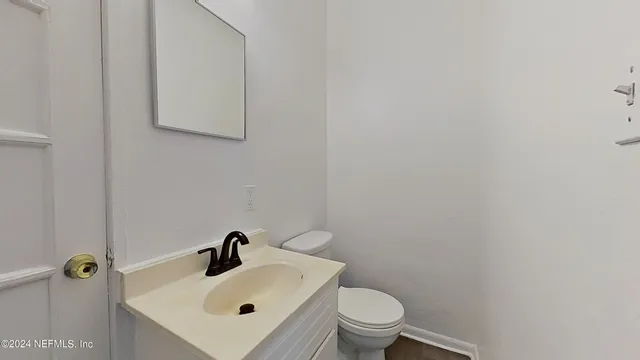 a bathroom with a sink and mirror with toilet