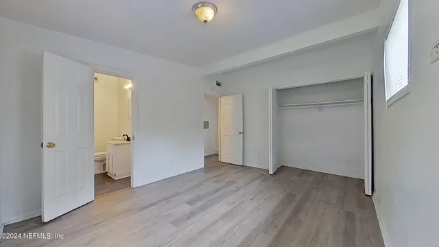 an empty room with wooden floor and a window