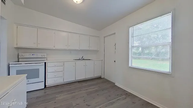 a kitchen with wooden cabinets and a stove