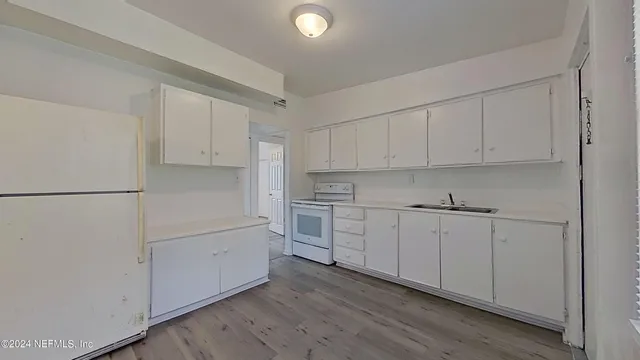 a kitchen with white cabinets and white appliances