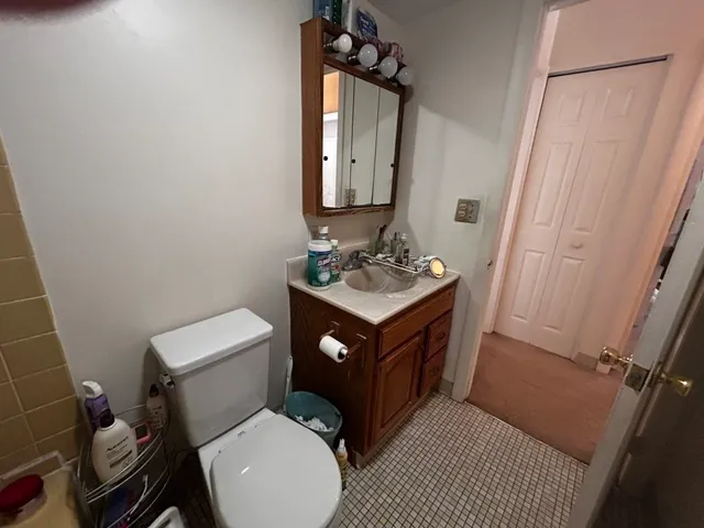 a bathroom with a sink vanity mirror and toilet