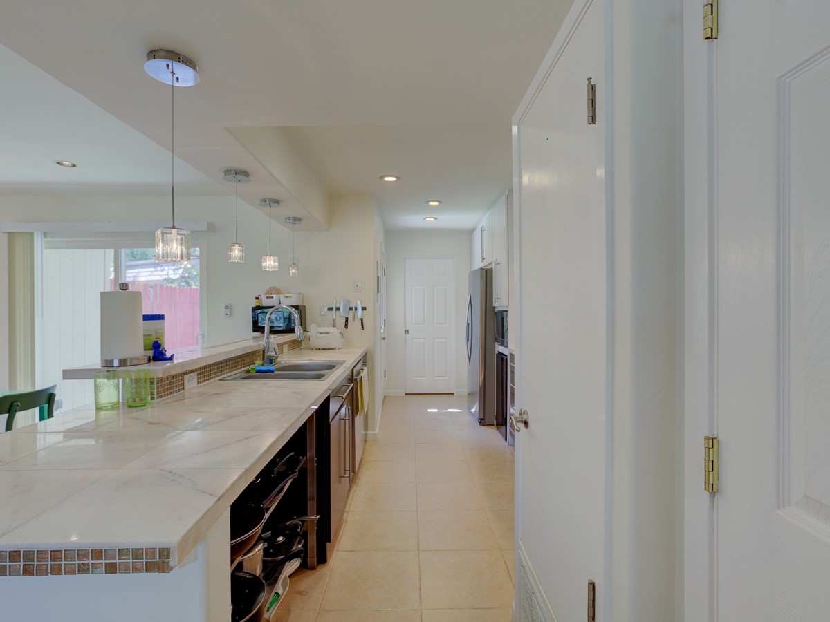 710 Castle Ridge Road, Unit B Austin, TX 78746 - Photo 4 of 27 A well-lit galley kitchen offers generous counter space and seamless functionality for culinary endeavors.