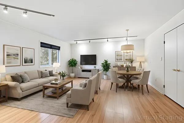 a living room with furniture a flat screen tv and a wooden floor