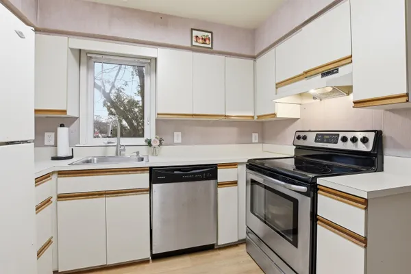 a kitchen with cabinets appliances and a window
