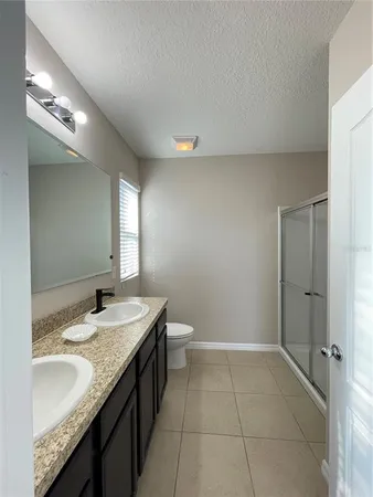 a spacious bathroom with a granite countertop sink a toilet and a mirror