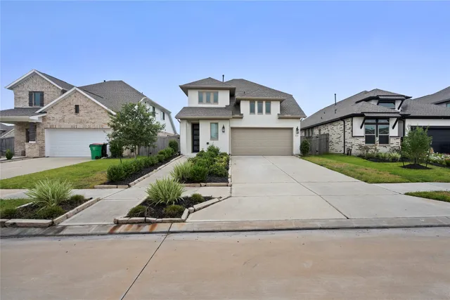 a front view of a house with a garden and plants