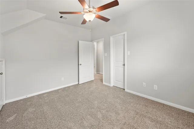 an empty room with closet and a chandelier fan