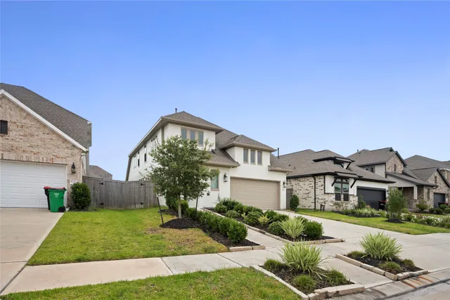 a front view of a house with a yard and a garden