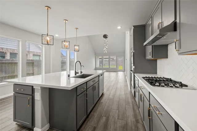 a kitchen with stainless steel appliances granite countertop a sink stove and cabinets