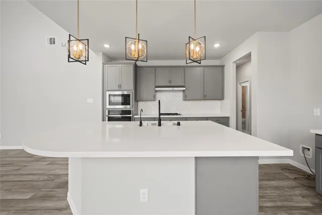 a view of a kitchen with stainless steel appliances granite countertop a sink and a refrigerator