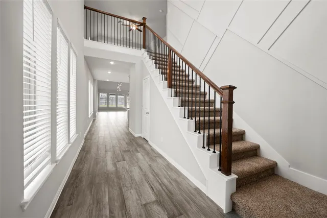 a view of staircase with wooden floor and white walls