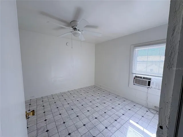 an empty room with windows and fan